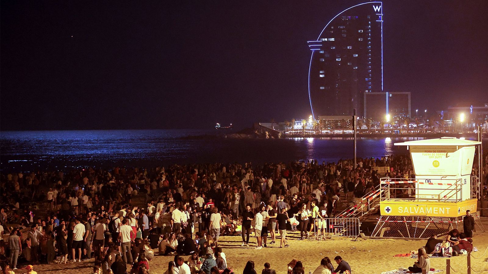 Cientos de personas celebran en la playa de la Barceloneta la noche de San Juan.