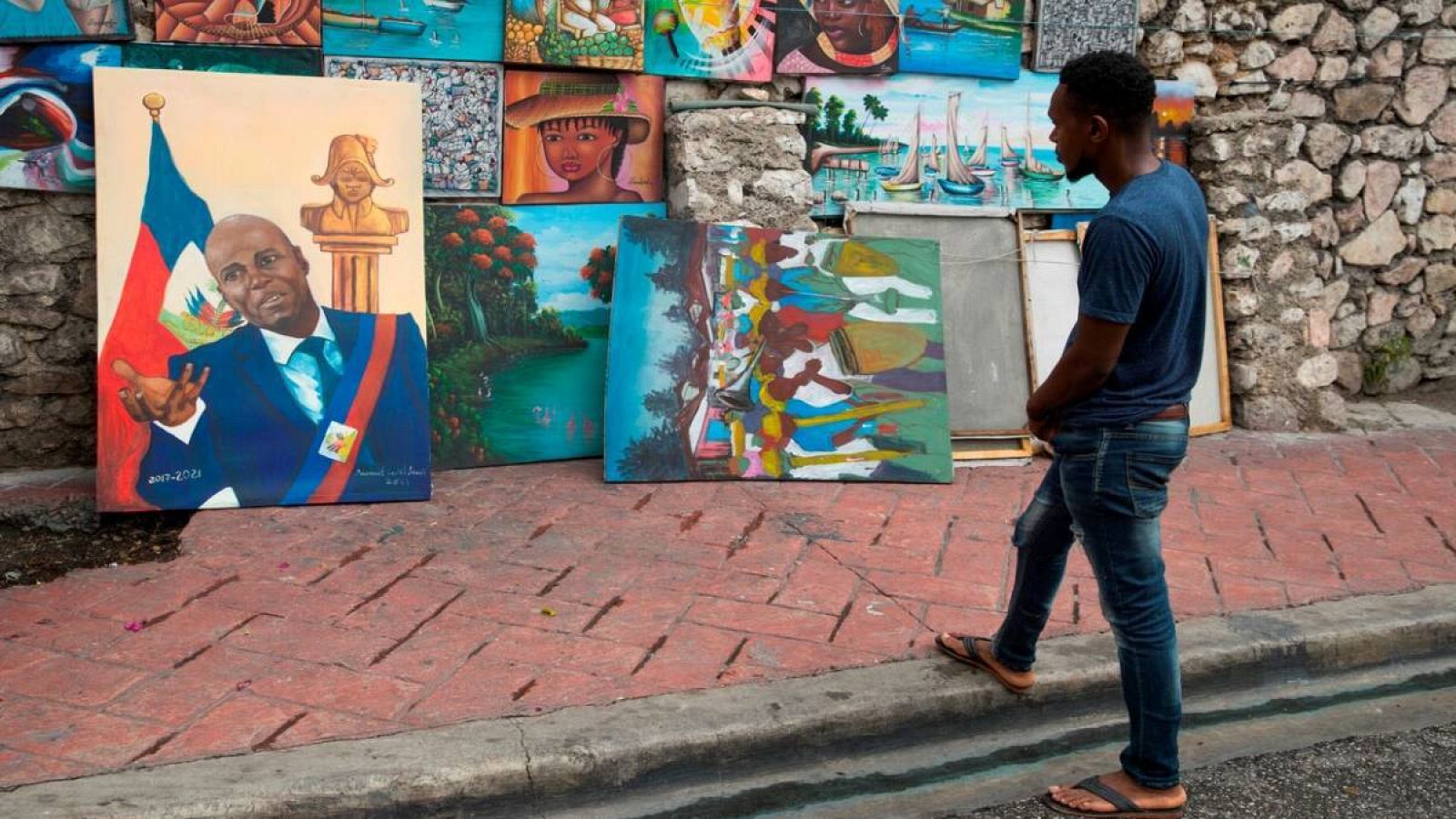El artista Samuel Saint Louis sostiene una pintura del presidente Jovenel Moise, que pintó en los últimos tres días, en Puerto Príncipe (Haití).