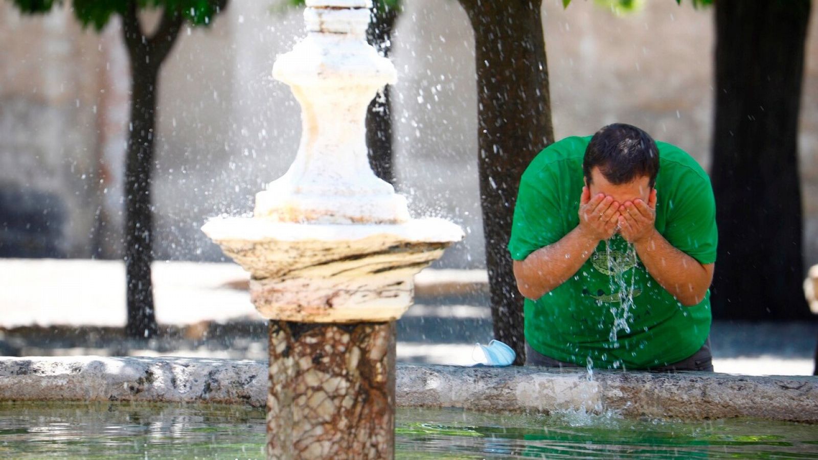 Un hombre se refresca en una fuente de Córdoba, una de las provincias en alerta amarilla