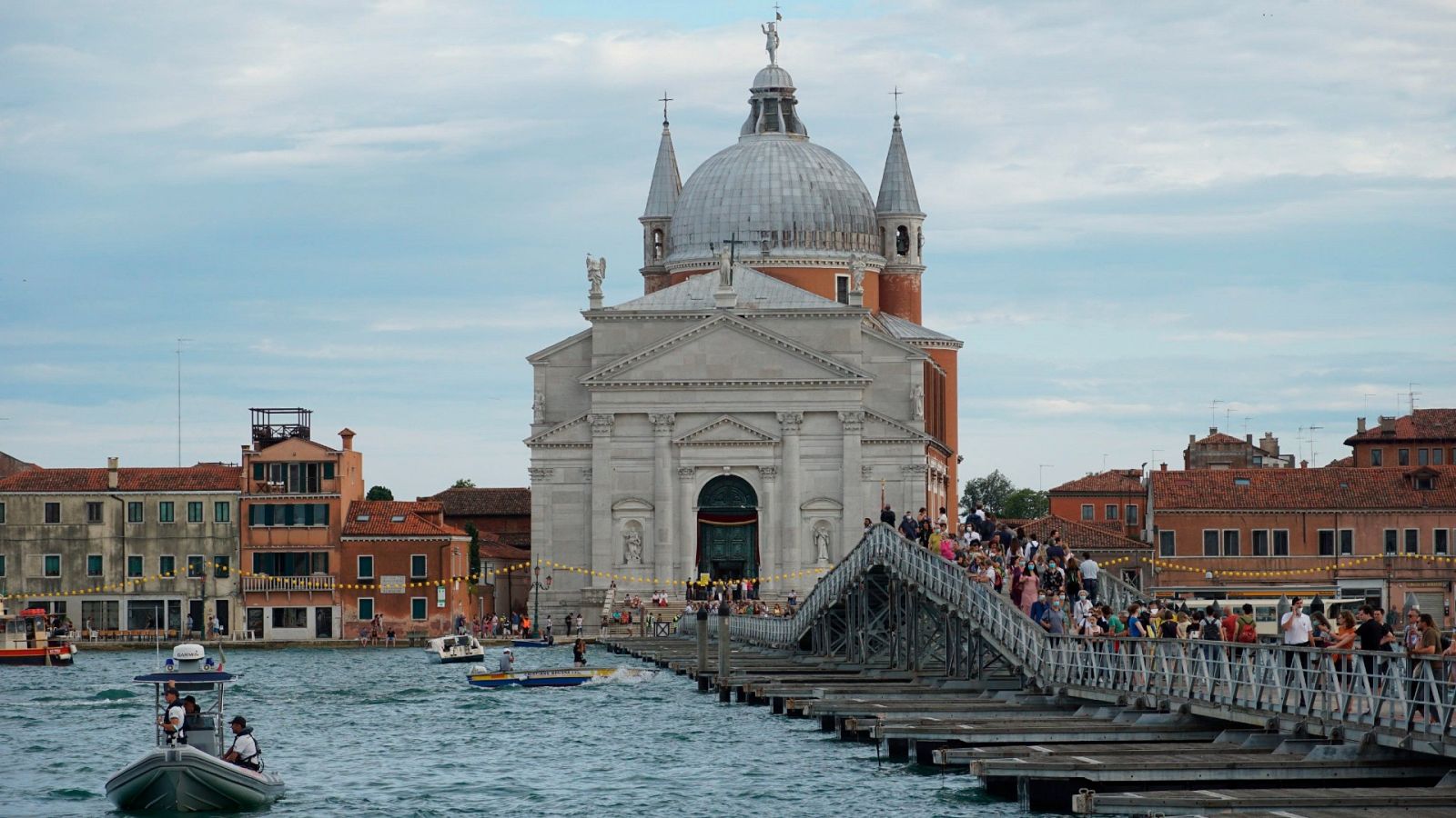 Peregrinos y turistas cruzan el puente que conecta las orillas opuestas del Canal de la Giudecca, para llegar a la Iglesia del Redentor, en vísperas de la Festa del Redentore en Venecia, Italia
