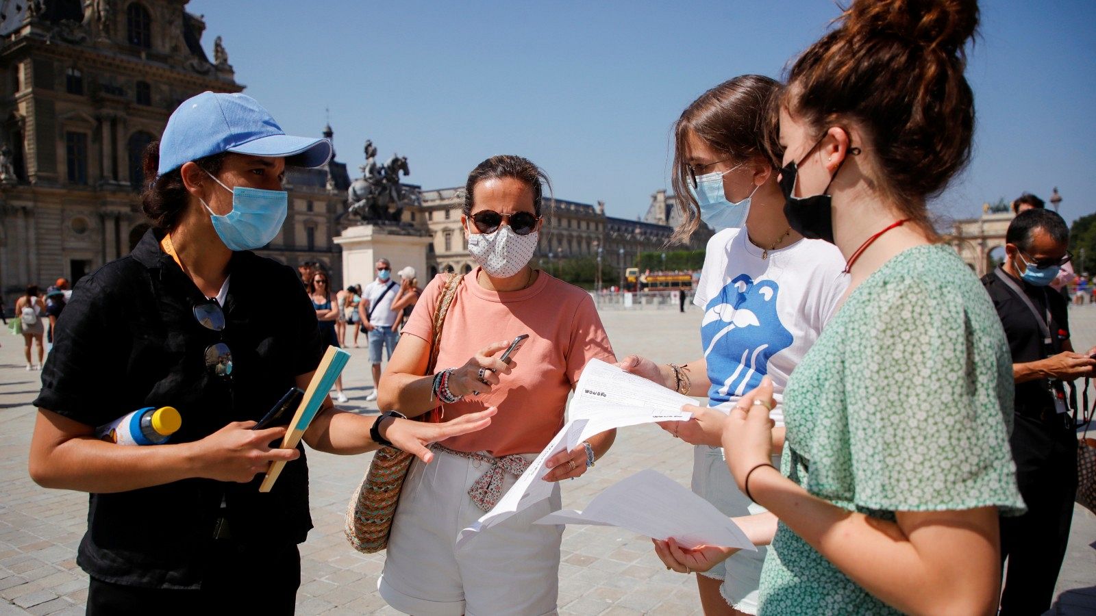 Un agente de seguridad comprueba los certificados COVID de las visitantes al Louvre, en París