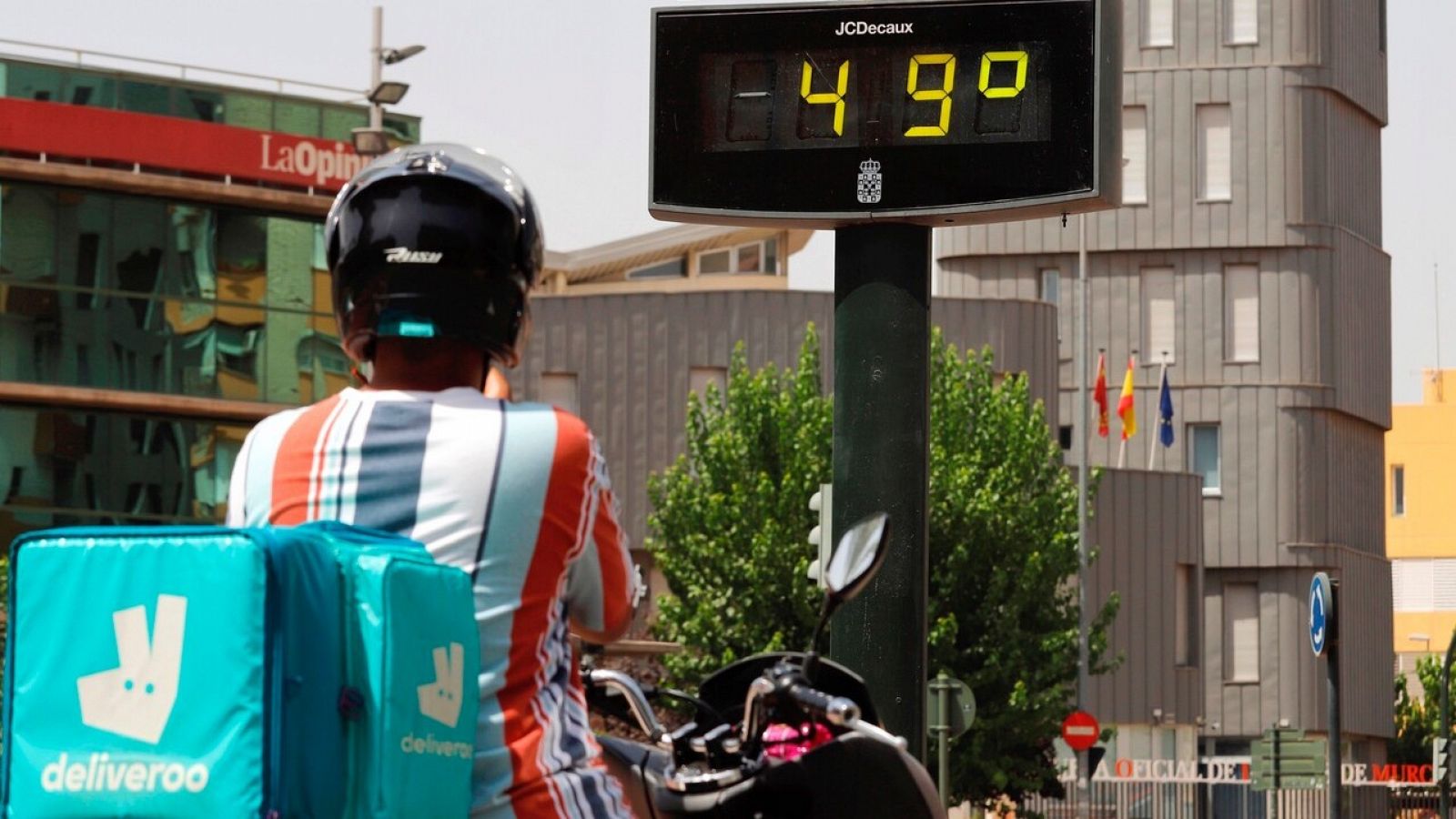 Un repartidor junto a un termómetro en Murcia, este domingo