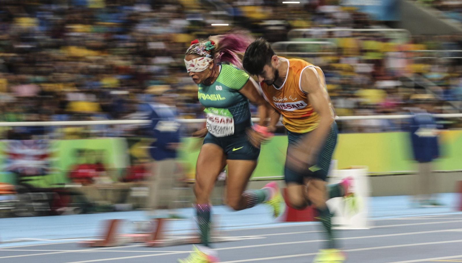 La atleta brasileña Terezinha Guilhermida corriendo junto a su deportista de apoyo en la prueba 200 m T11