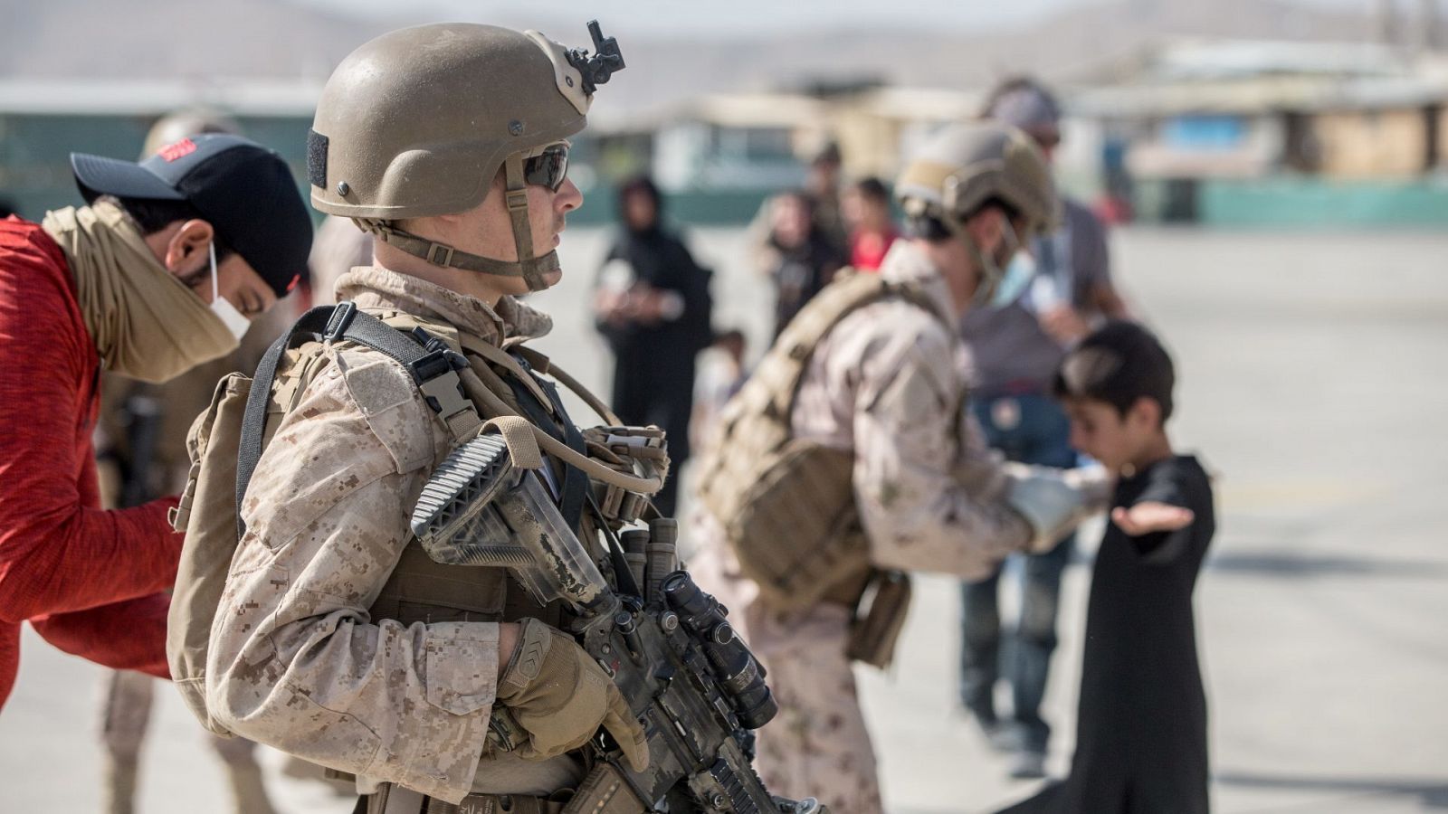 Un marine estadounidense presta asistencia durante la evacuación en el aeropuerto