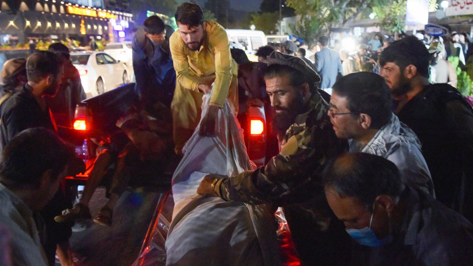 Personal sanitario traslada a un fallecido en el doble atentado cerca del aeropuerto de Kabul.