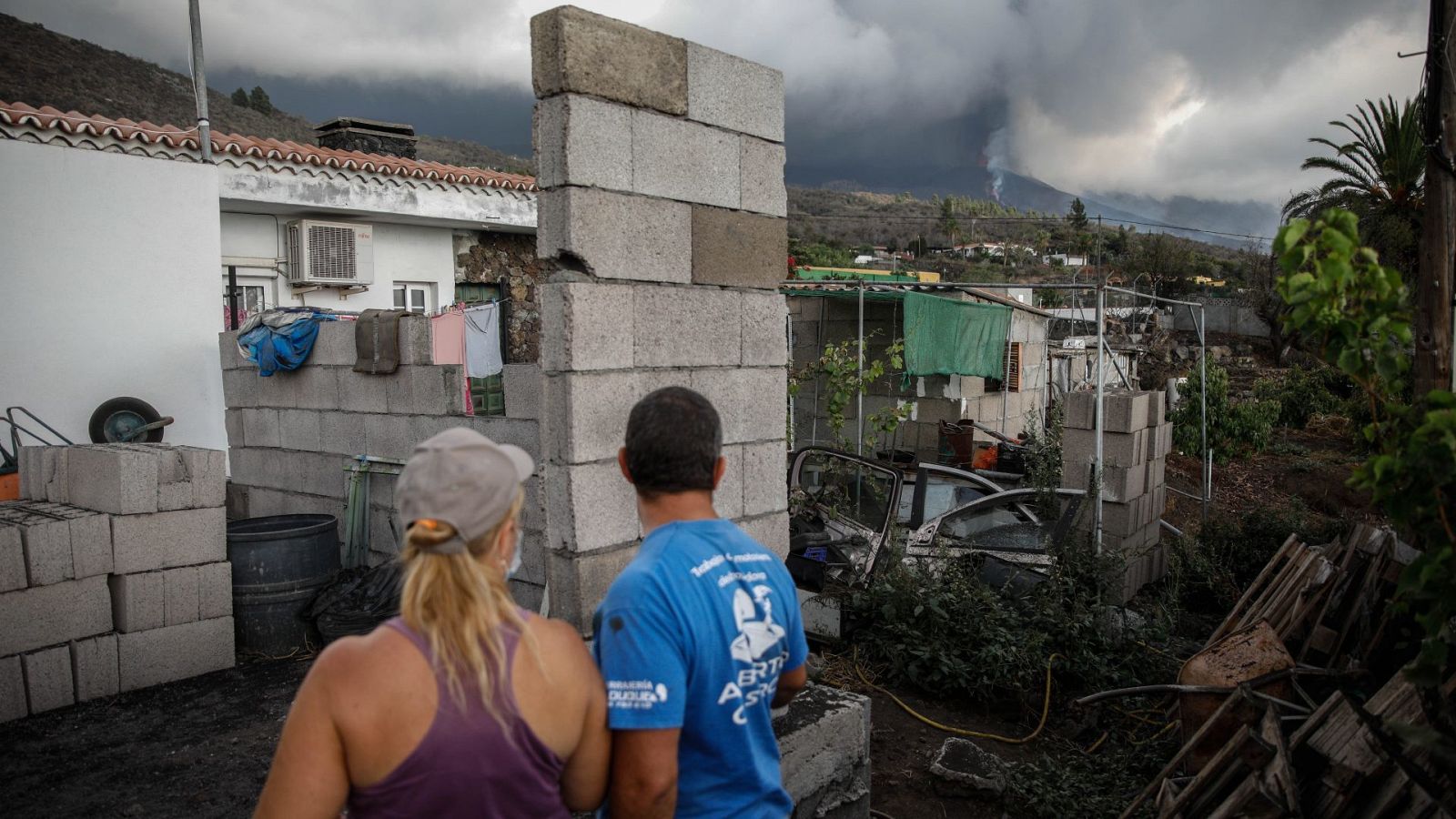 Un hombre y una mujer sacan sus pertenencias de su casa por la actividad del volcán