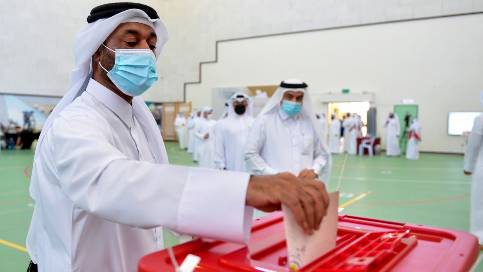 Un hombre depositando su voto en una urna de un colegio electoral en Doha, Catar.