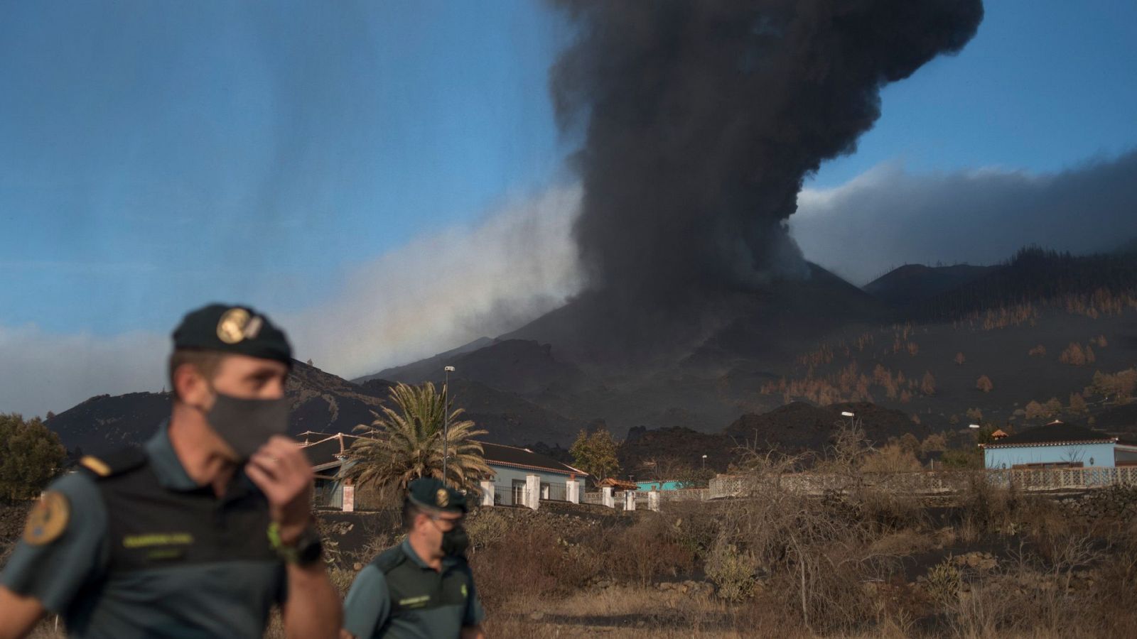 El volcán de Cumbre Vieja visto desde Las Manchas, arroja lava y una nube de humo y cenizas. 