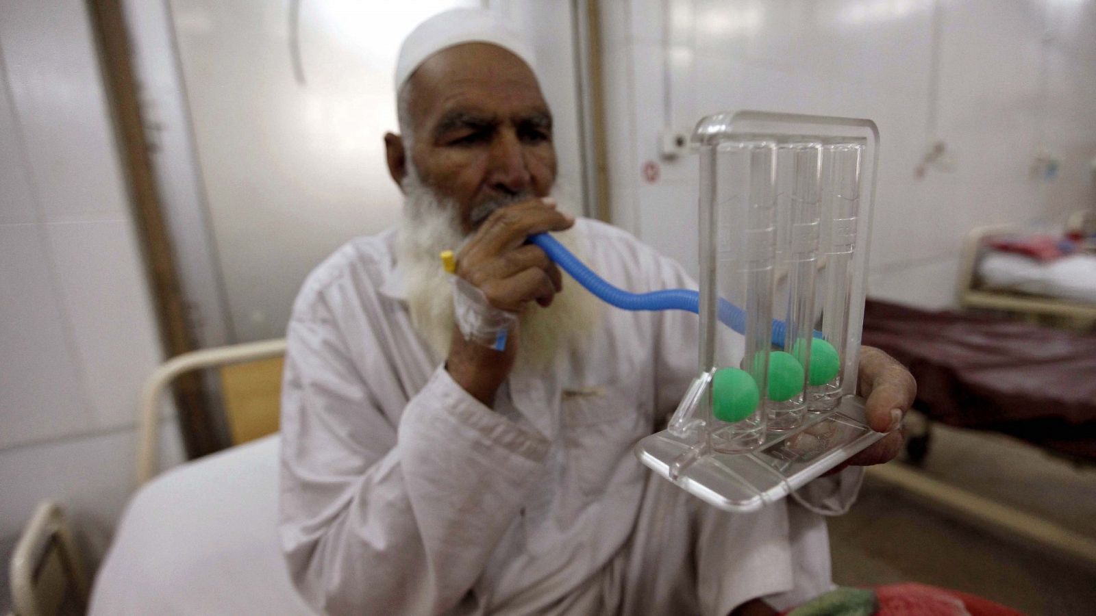 Un paciente que padece tuberculosis sopla aire como parte del tratamiento médico