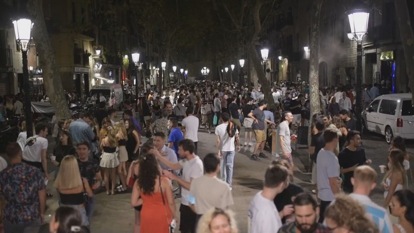 Un grupo numeroso de jóvenes ocupa una calle durante la noche.