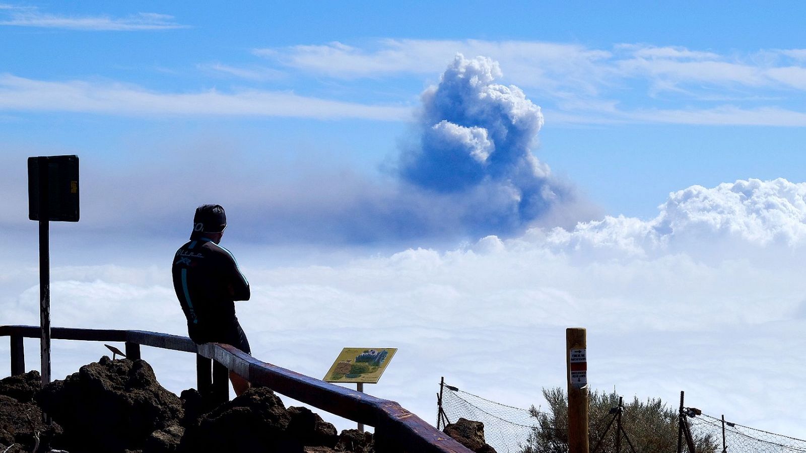 Un hombre mira la columna de humo que sale del volcán de La Palma.