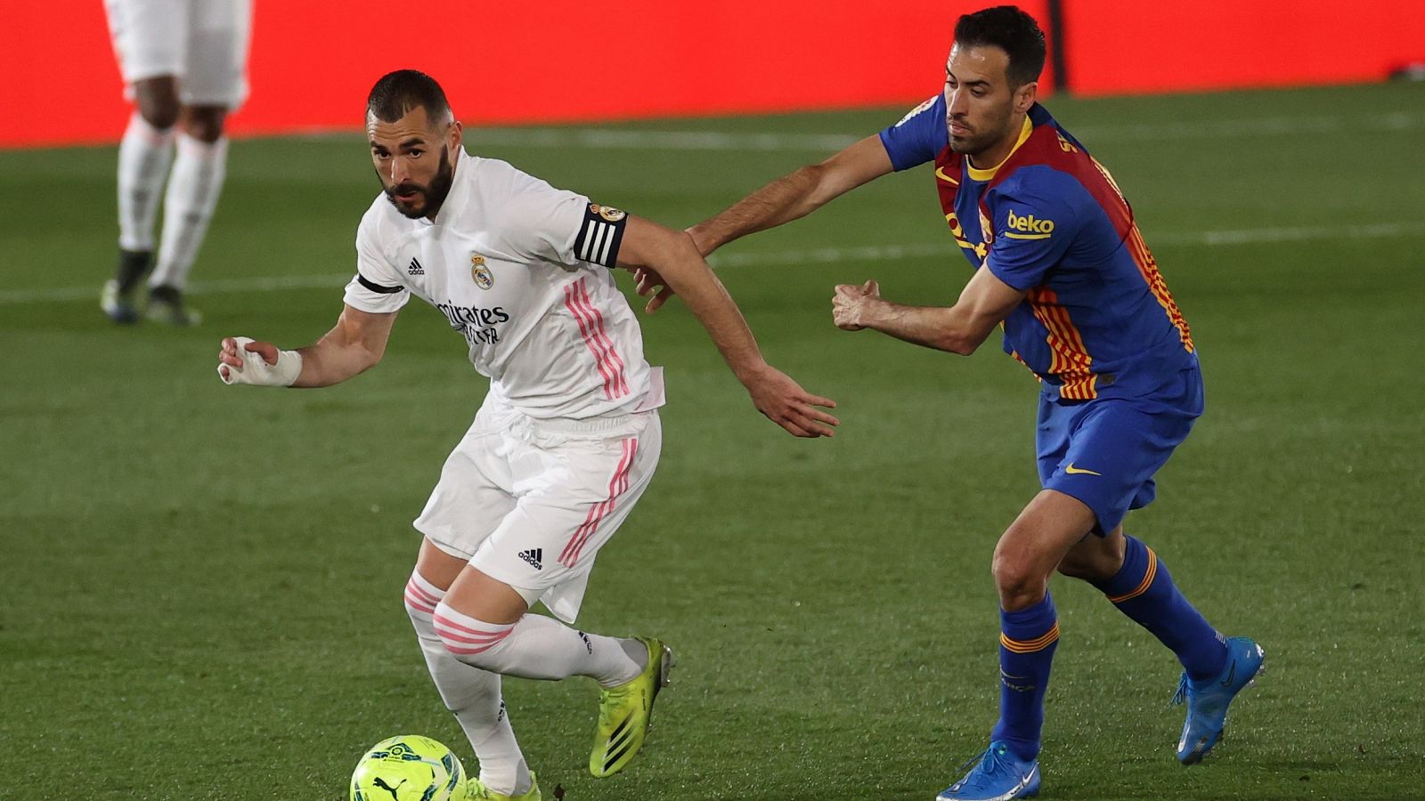 El delantero del Real Madrid Karim Benzema (i) se escapa de Sergio Busquets, del FC Barcelona