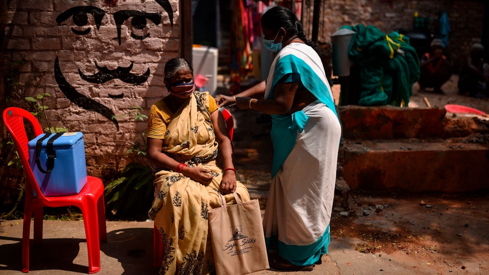 Una sanitaria administra una dosis de la vacuna contra la COVID-19 a una anciana en Chennai, en India.