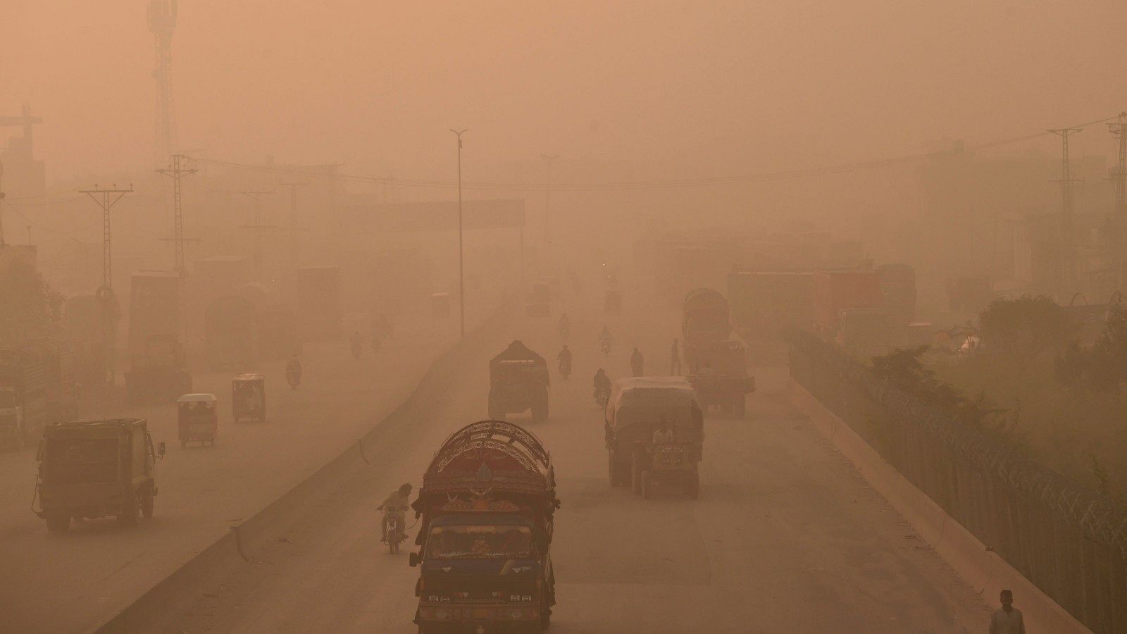 Viajeros circulan por una carretera sumida en niebla y humo en Lahore, Pakistán, en octubre de 2021.