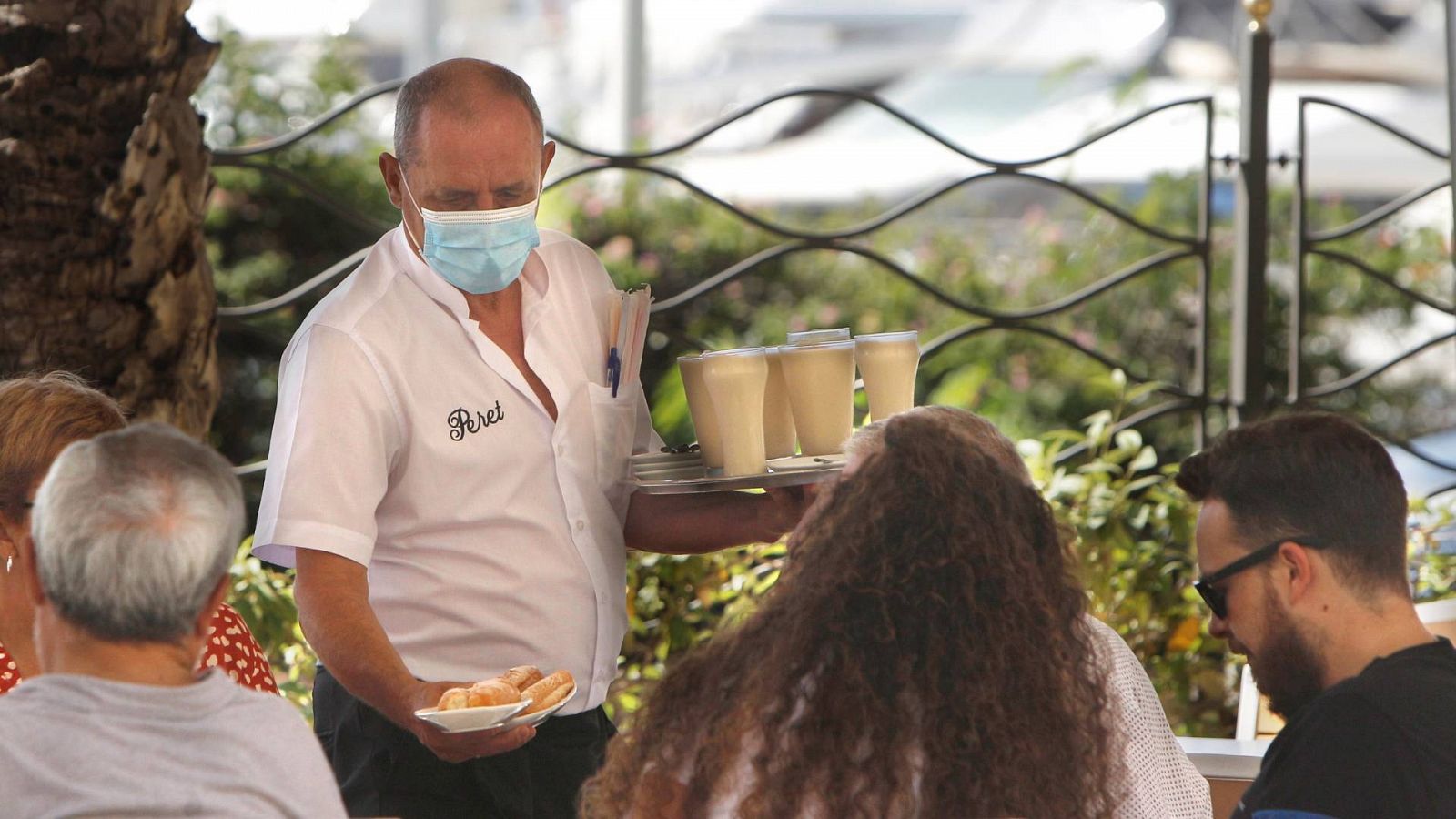 Un camarero sirve una mesa en una terraza de Alicante
