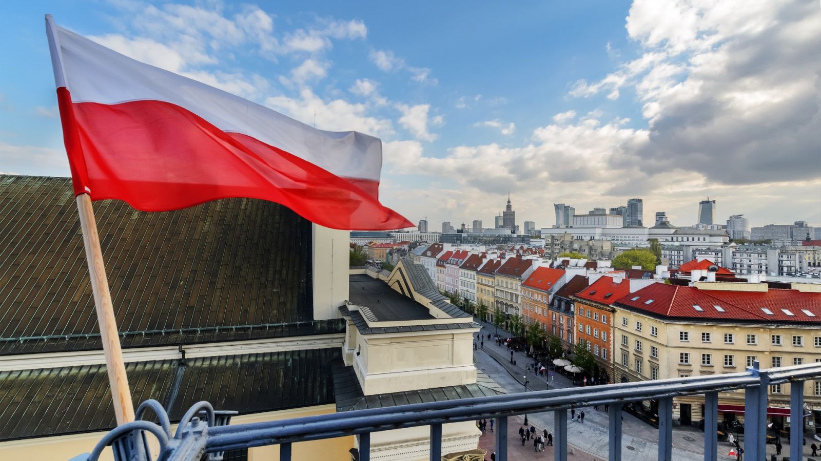Una bandera de Polonia ondeando con Varsovia de fondo