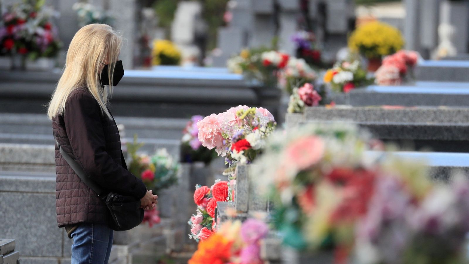 Una mujer visita la tumba de un familiar en el cementerio de la Almudena