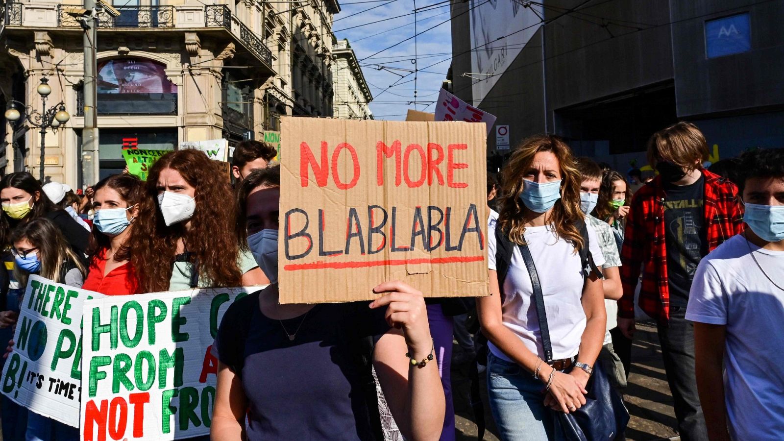 Una joven cologista lleva un cartel en el que se lee "No más blablabla" en una manifestación