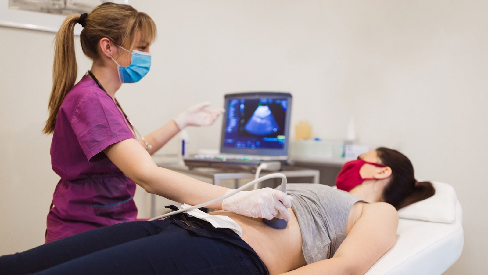 Una sanitaria realiza una ecografía a una mujer embarazada.