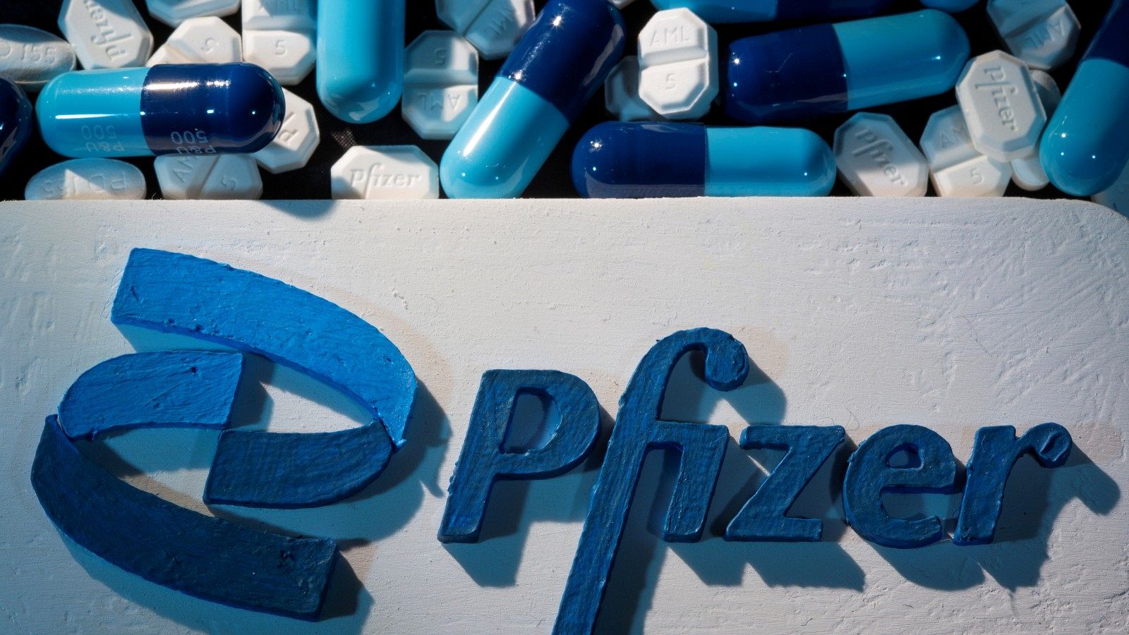 El logotipo de Pfizer junto a píldoras azules en una imagen de archivo.