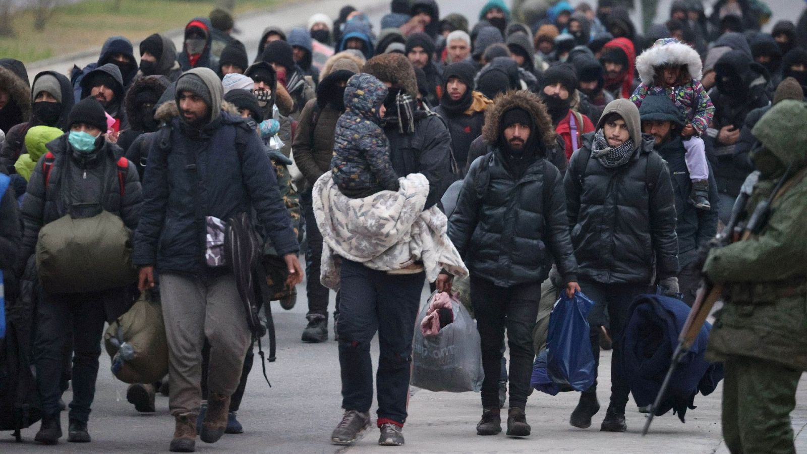 Migrantes caminan hacia el centro de transporte y logística de Bruzgi en la frontera entre Bielorrusia y Polonia