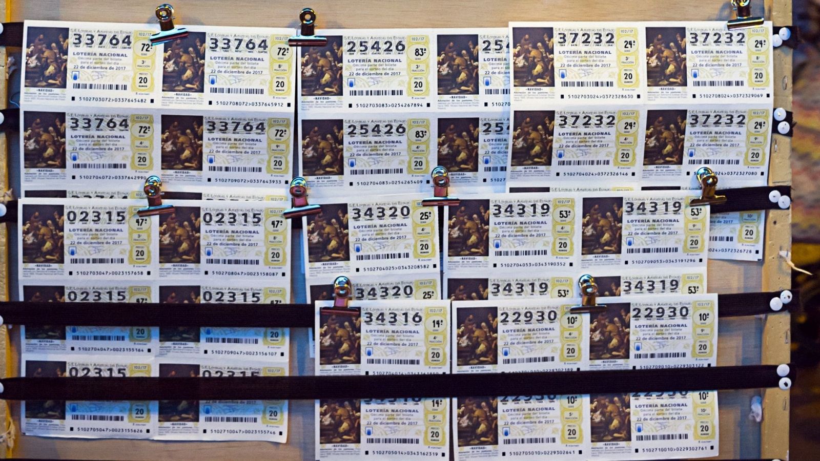 Un montón de décimos de lotería colgados con distintos números