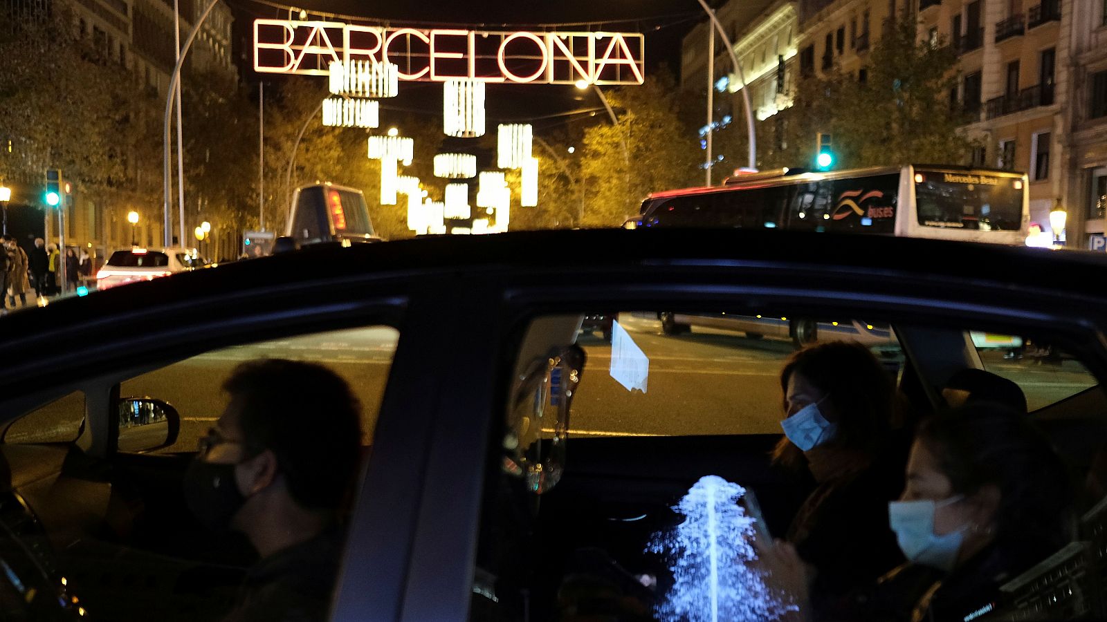 Dos mujeres viajan en taxi en Barcelona, con la iluminación navideña de fondo.