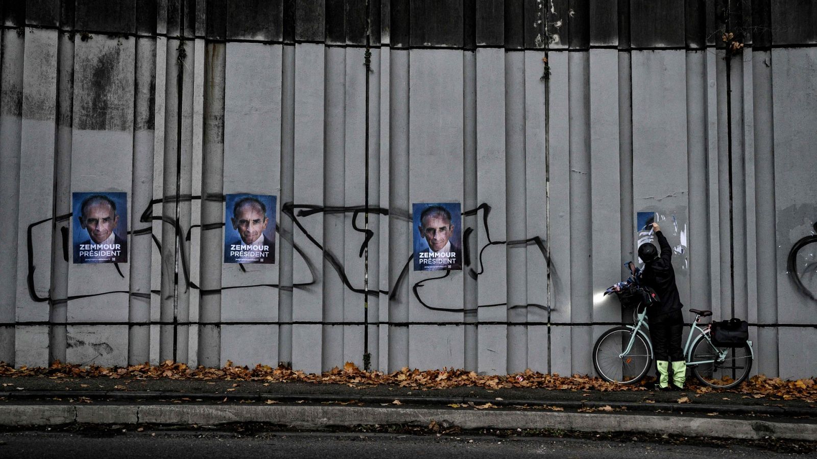 Un ciclista retira los carteles de campaña del utraderechista Zemmour
