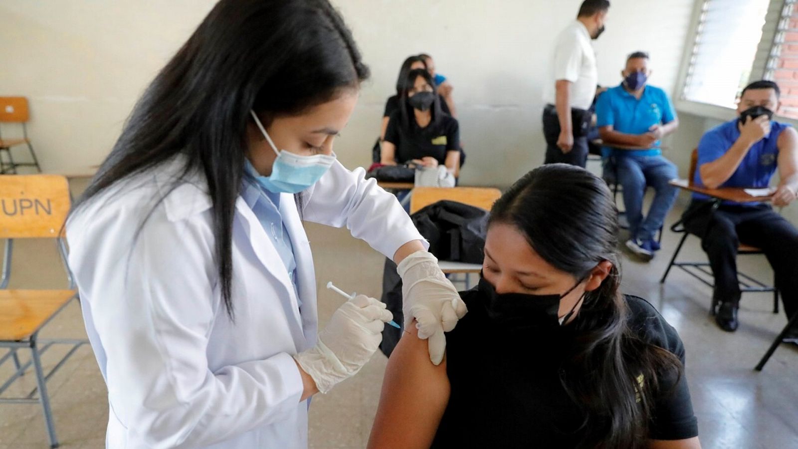 Una trabajadora de la Salud vacuna a una mujer contra el coronavirus en Tegucigalpa (Honduras). .EFE/ Gustavo Amador