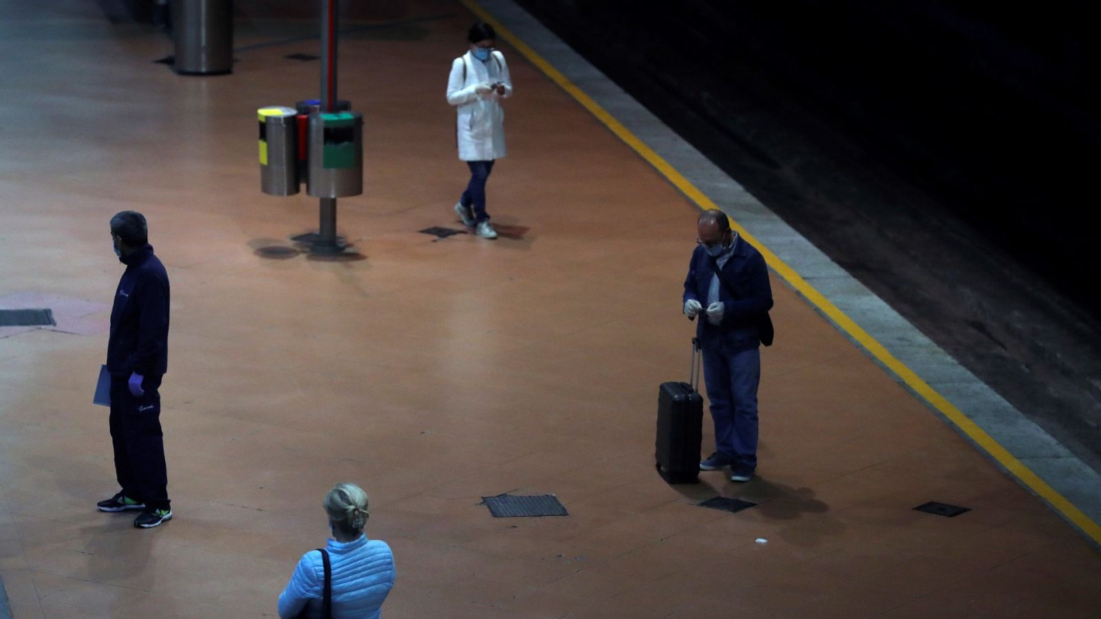Varias personas guardan la distancia social en la estación de Atocha de Madrid