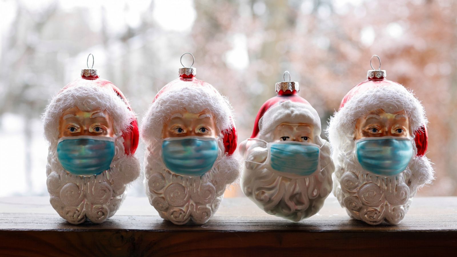 Bolas de Navidad con forma de Papá Noel llevando mascarilla contra el coronavirus, en un mercado navideño en Eichenau, Alemania.