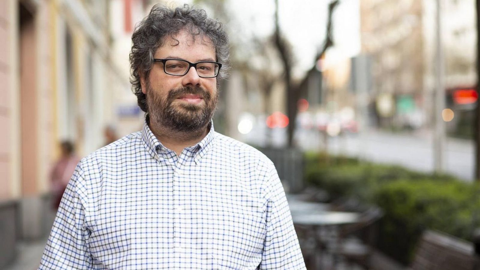 El periodista y escritor Sergio del Molino en una foto tomada en la calle de una ciudad con fondo desenfocado