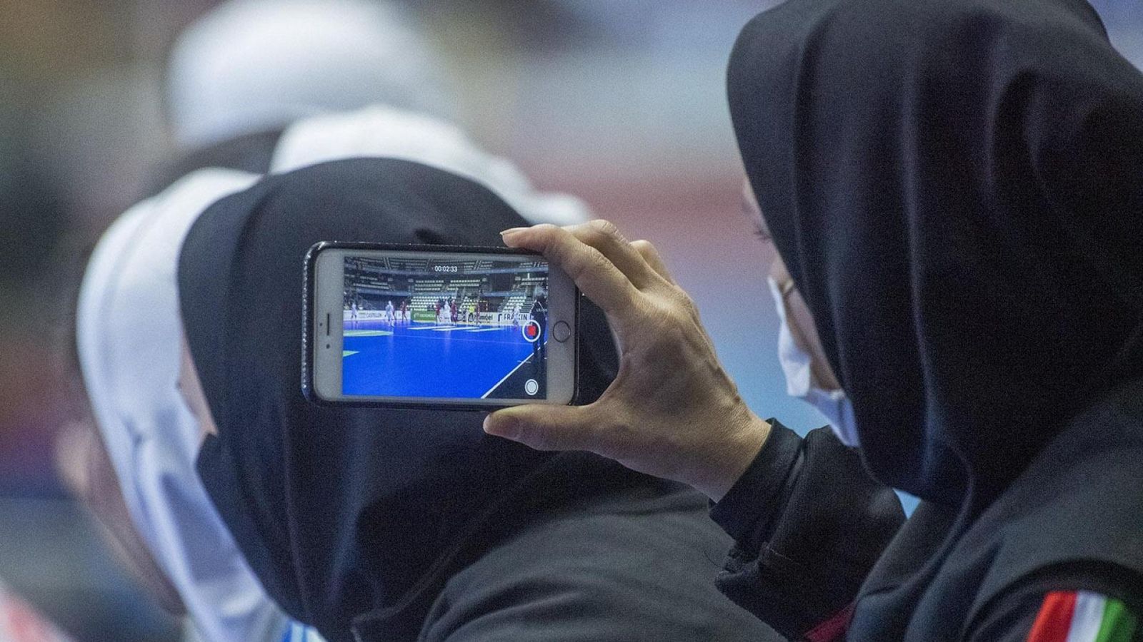 Imagen de dos jugadoras iraníes viendo el partido de su equipo desde el banquillo.