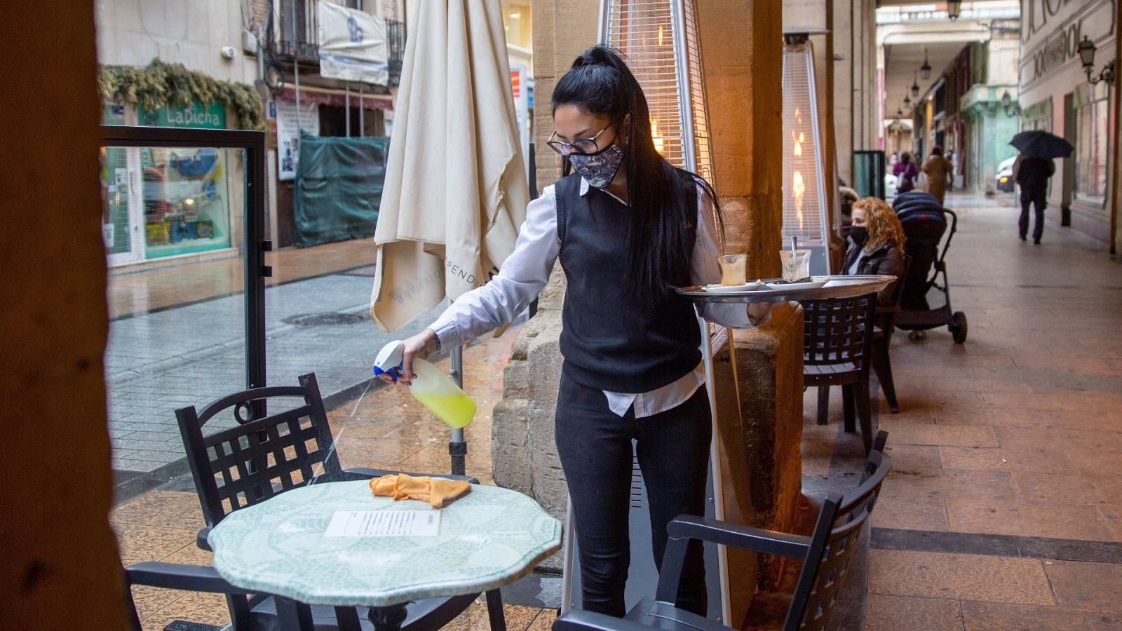 La camarera de un bar en la céntrica calle Portales de Logroño, limpia una mesa