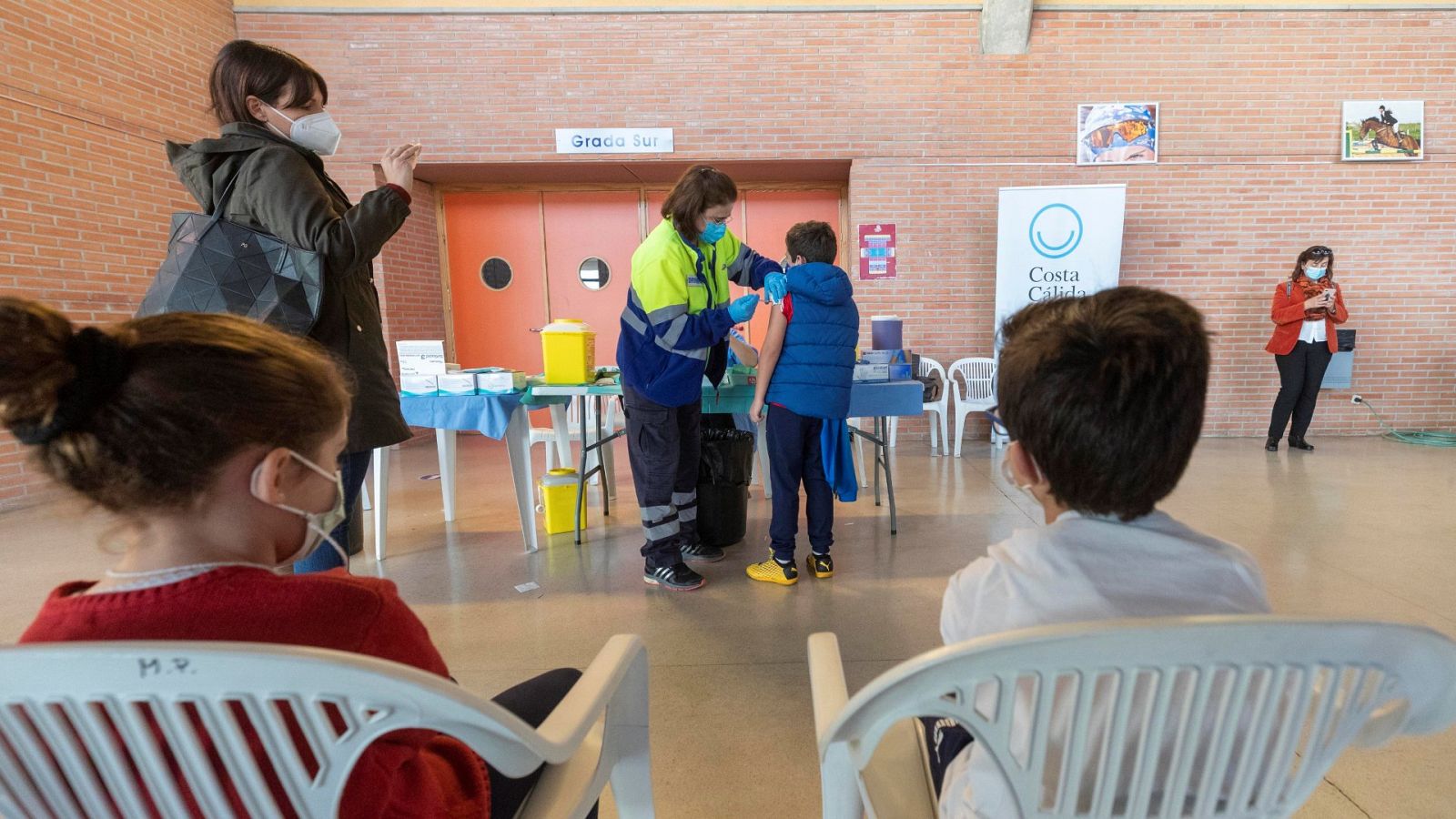 Una enfermera administra la vacuna de la COVID-19 a un niño en el Palacio de los Deportes de Murcia