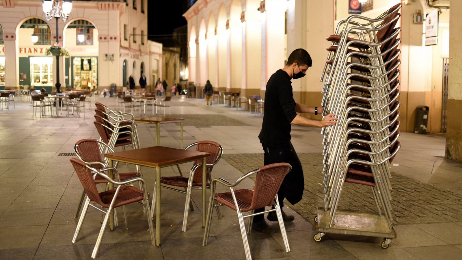 Un hostelero recoge la terraza de su establecimiento de Huesca