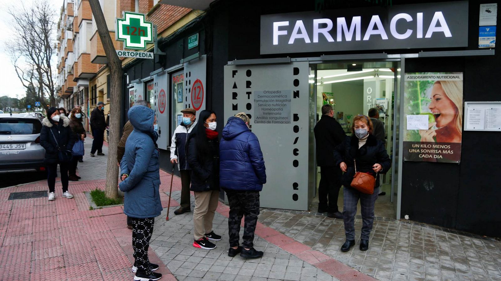 Gente haciendo cola para comprar test en una farmacia de Madrid