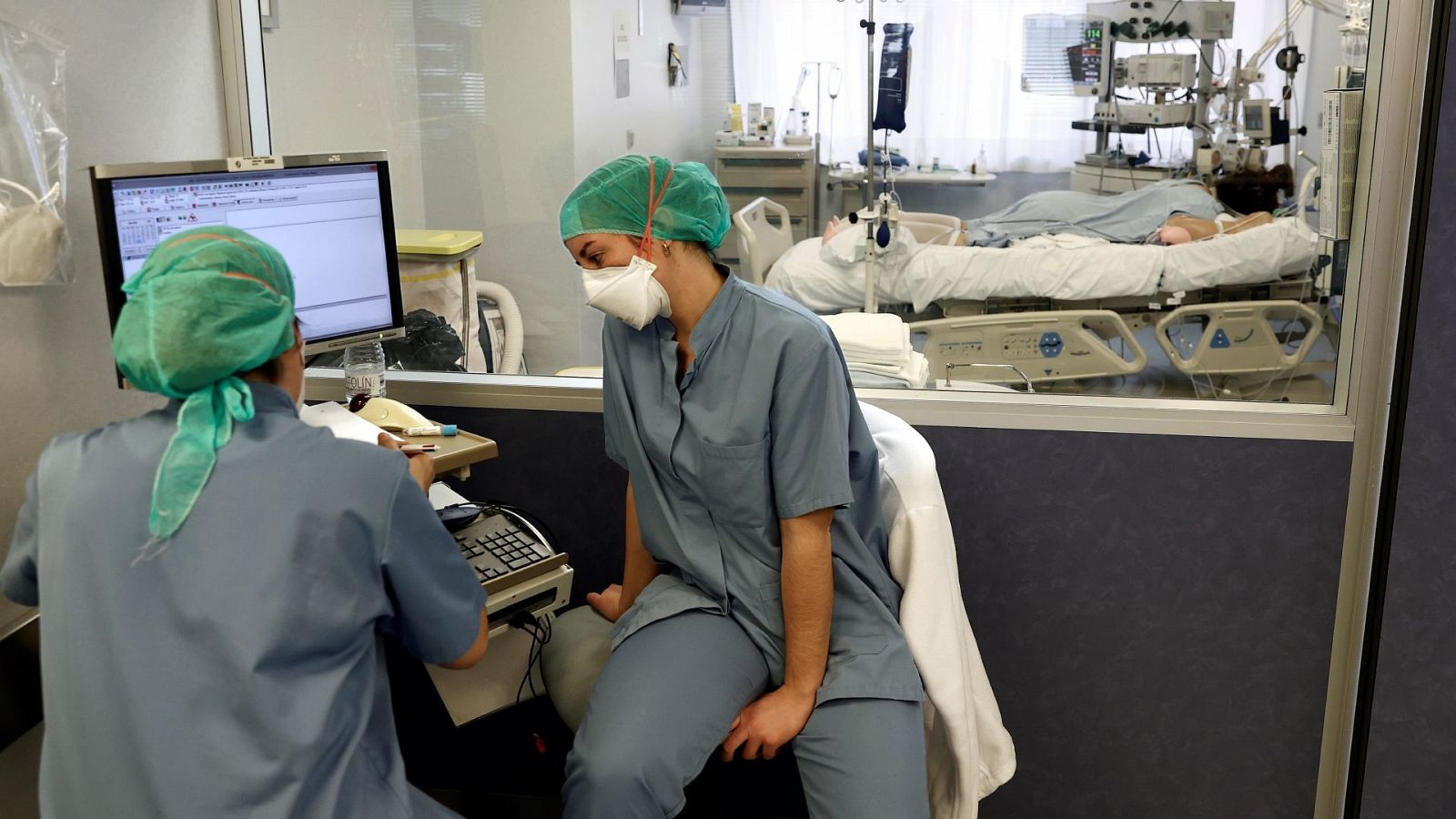Dos enfermeras leen el informe de un paciente COVID ingresado en la UCI de la Clínica Universidad de Navarra