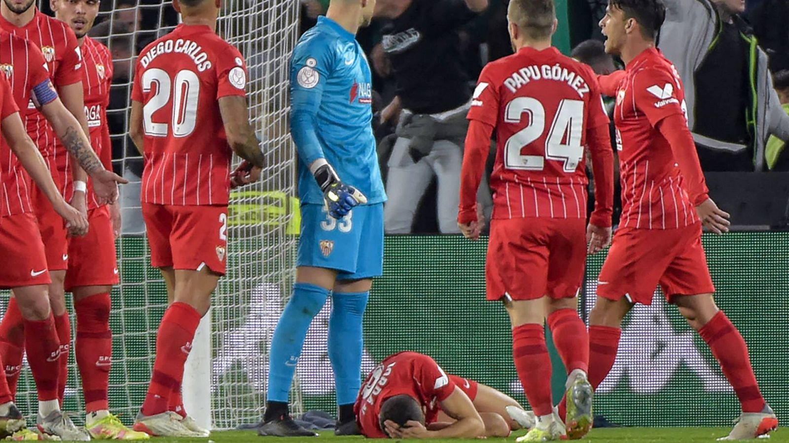 Joan Jordán, en el suelo, rodeado de compañeros del Sevilla, tras ser agredido en el campo del Betis