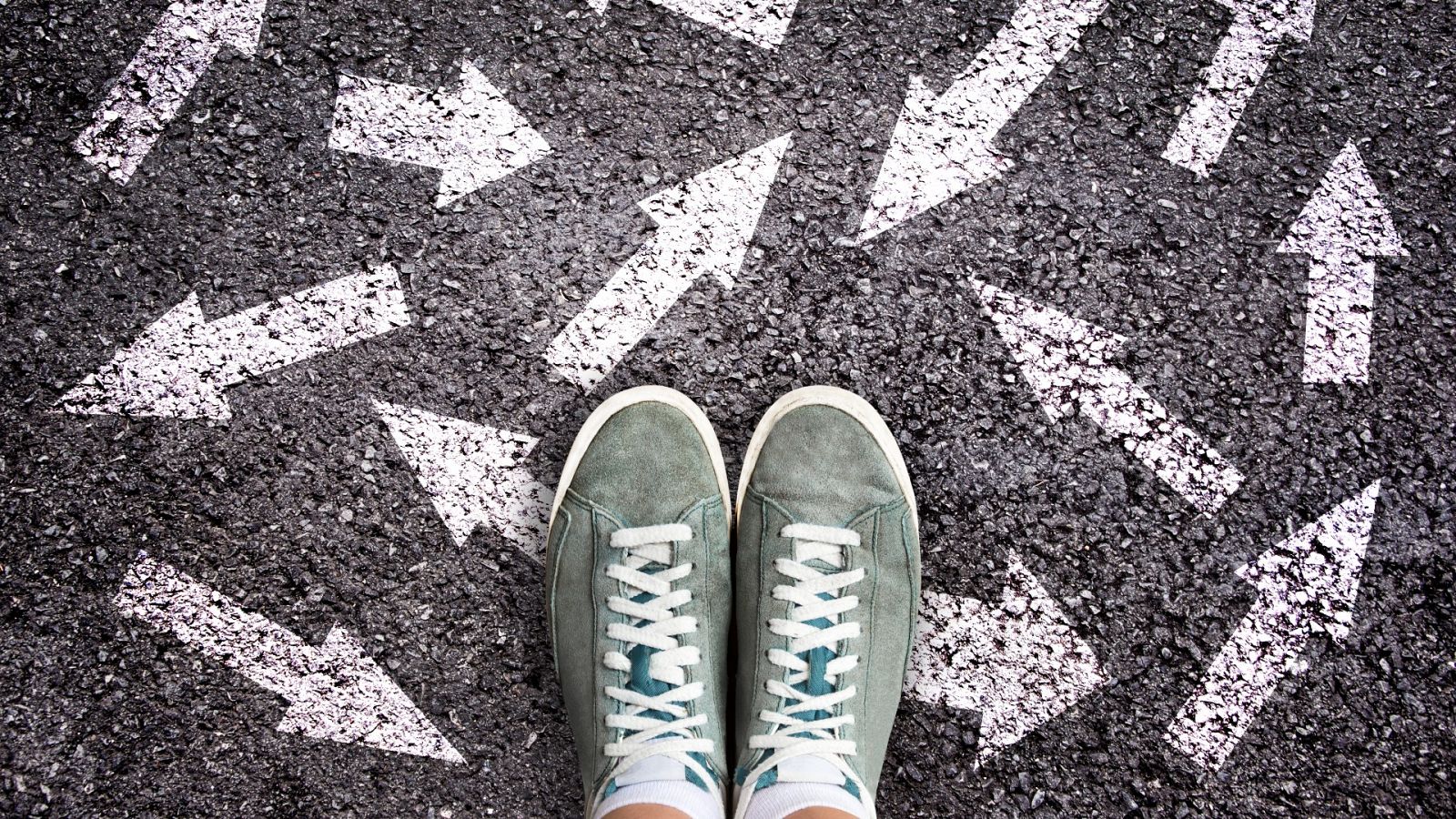 Los pies de un joven sobre un asfalto lleno de flechas