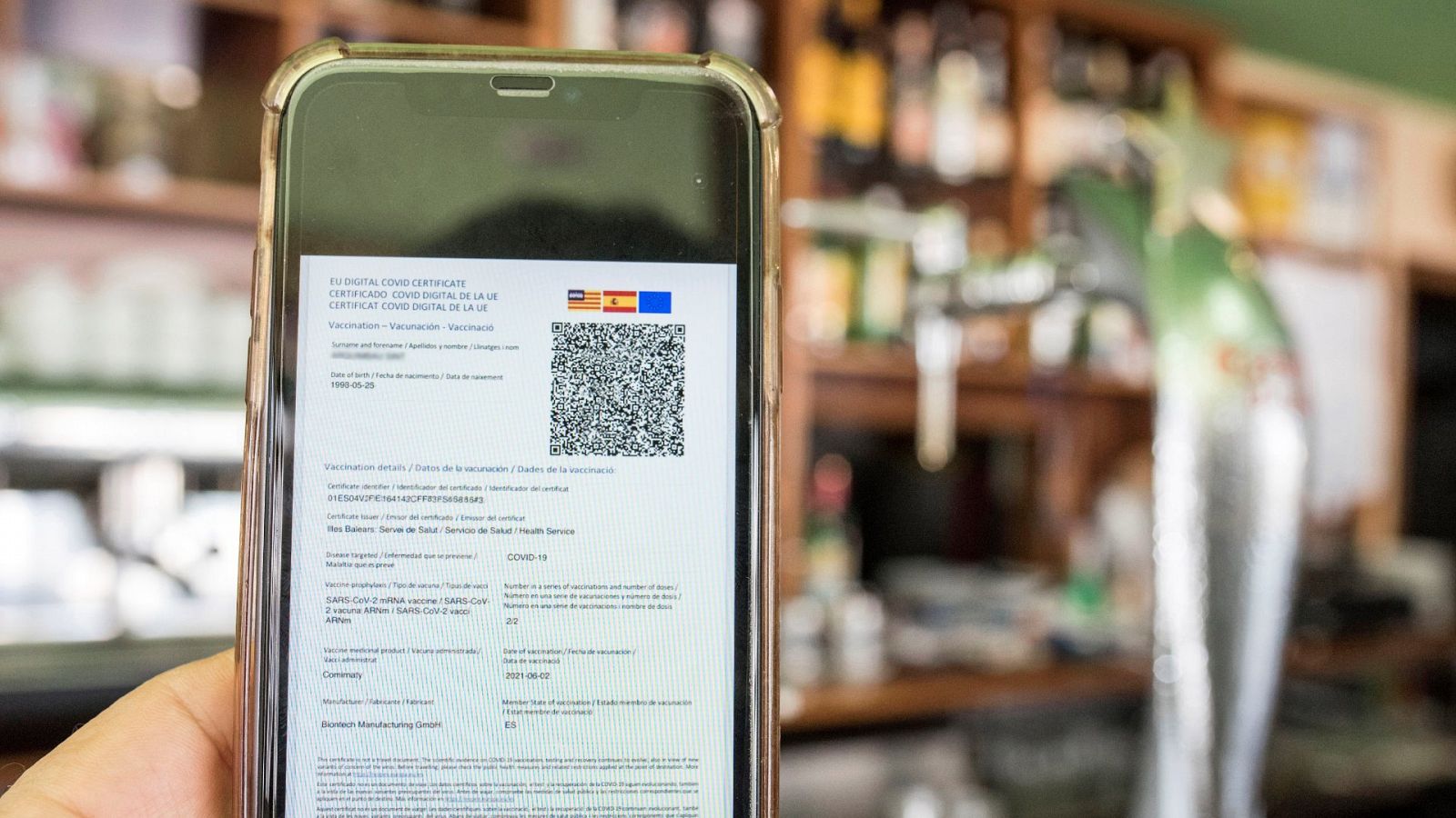 Detalle de un certificado COVID en un smartphone, en una cafetería de Menorca