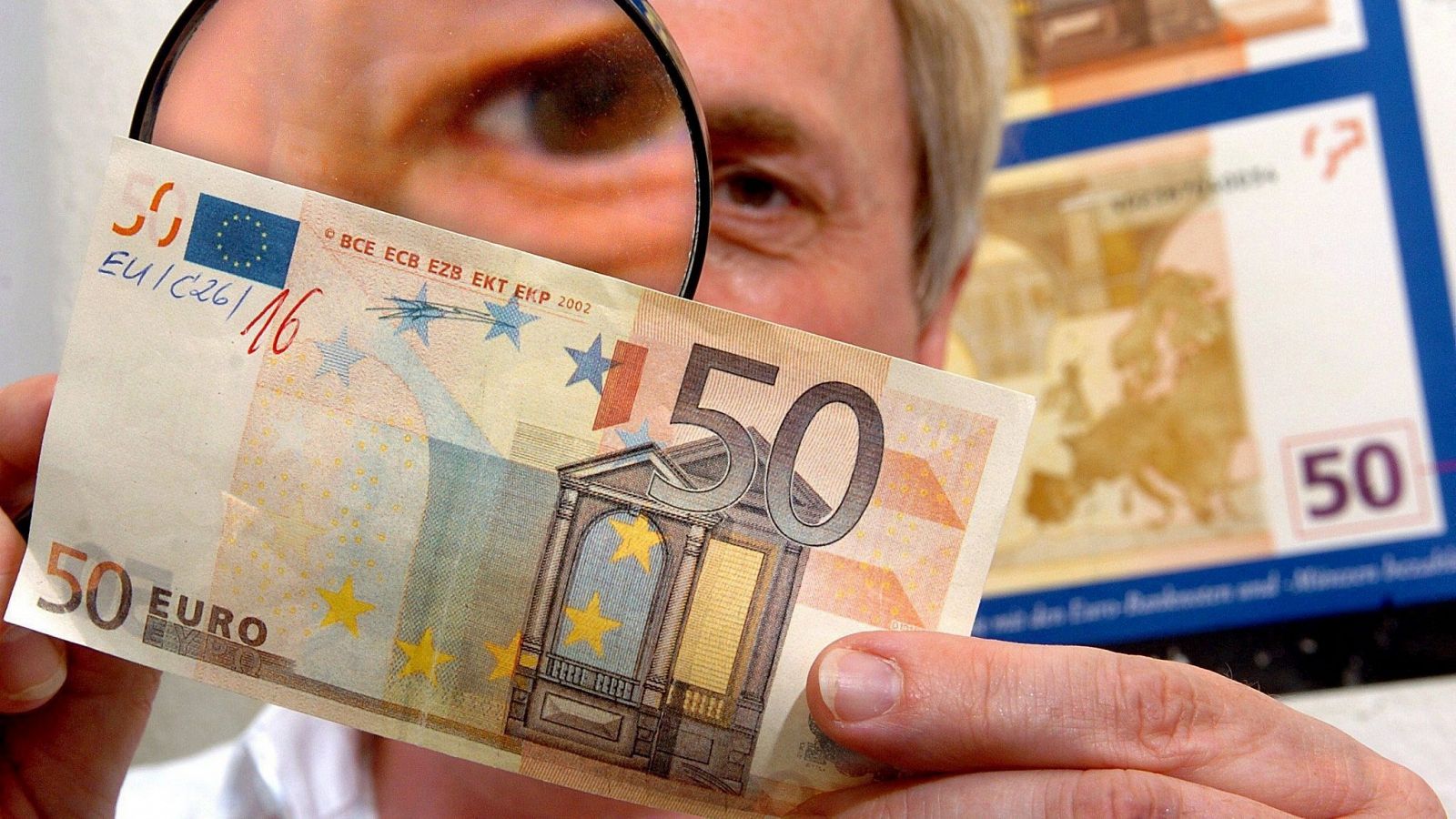Un experto examina un billete falso de 50 euros