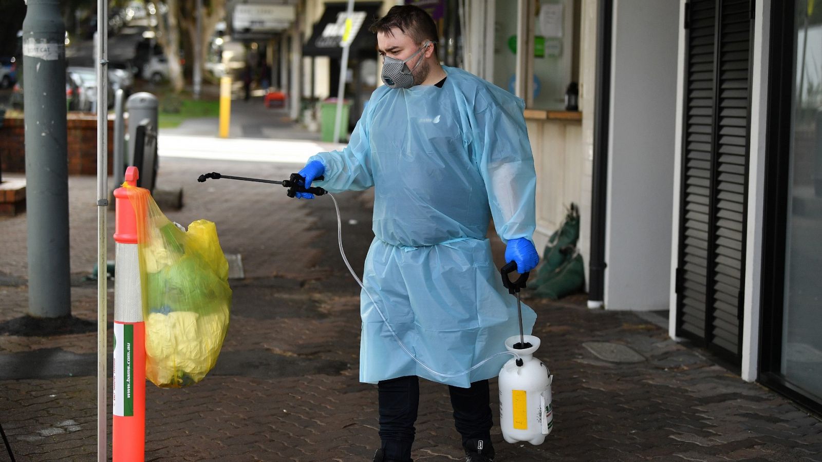 Una persona desinfecta la basura tras una desinfección en un restaurante de Sydney, Australia