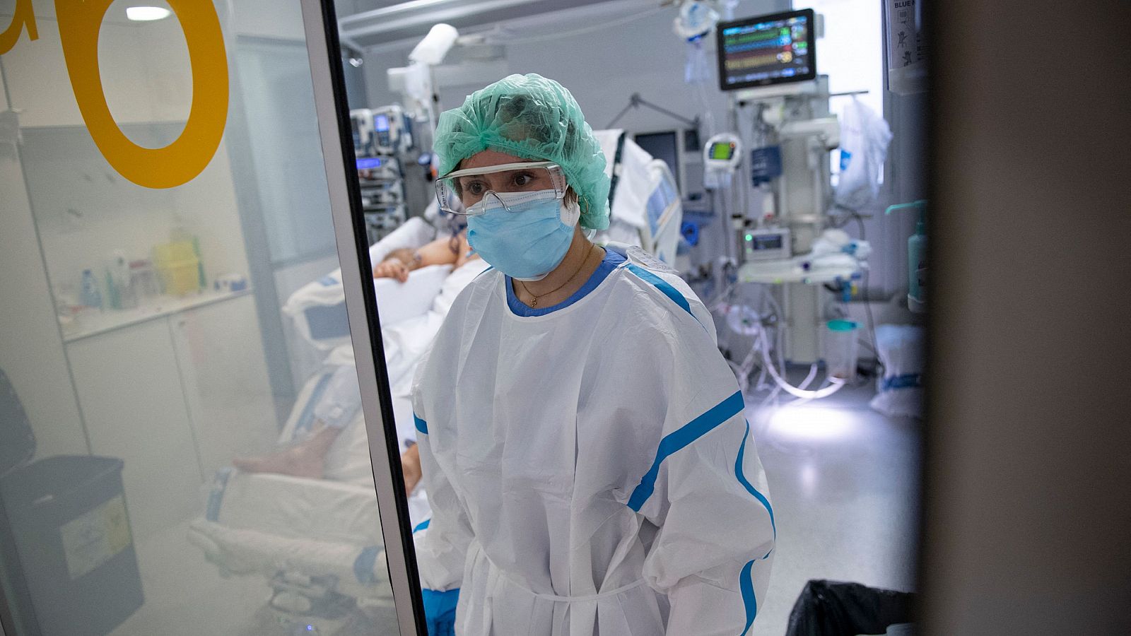 Una sanitaria atiende a un paciente ingresado en la UCI del Hospital de Bellvitge, en Barcelona.