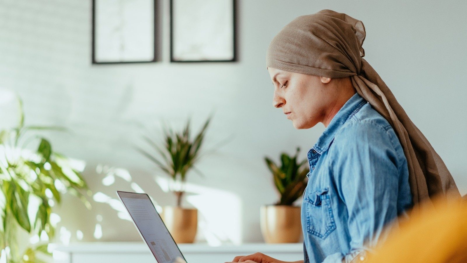 Una mujer con cáncer trabaja sentada frente a un ordenador, en una imagen de archivo