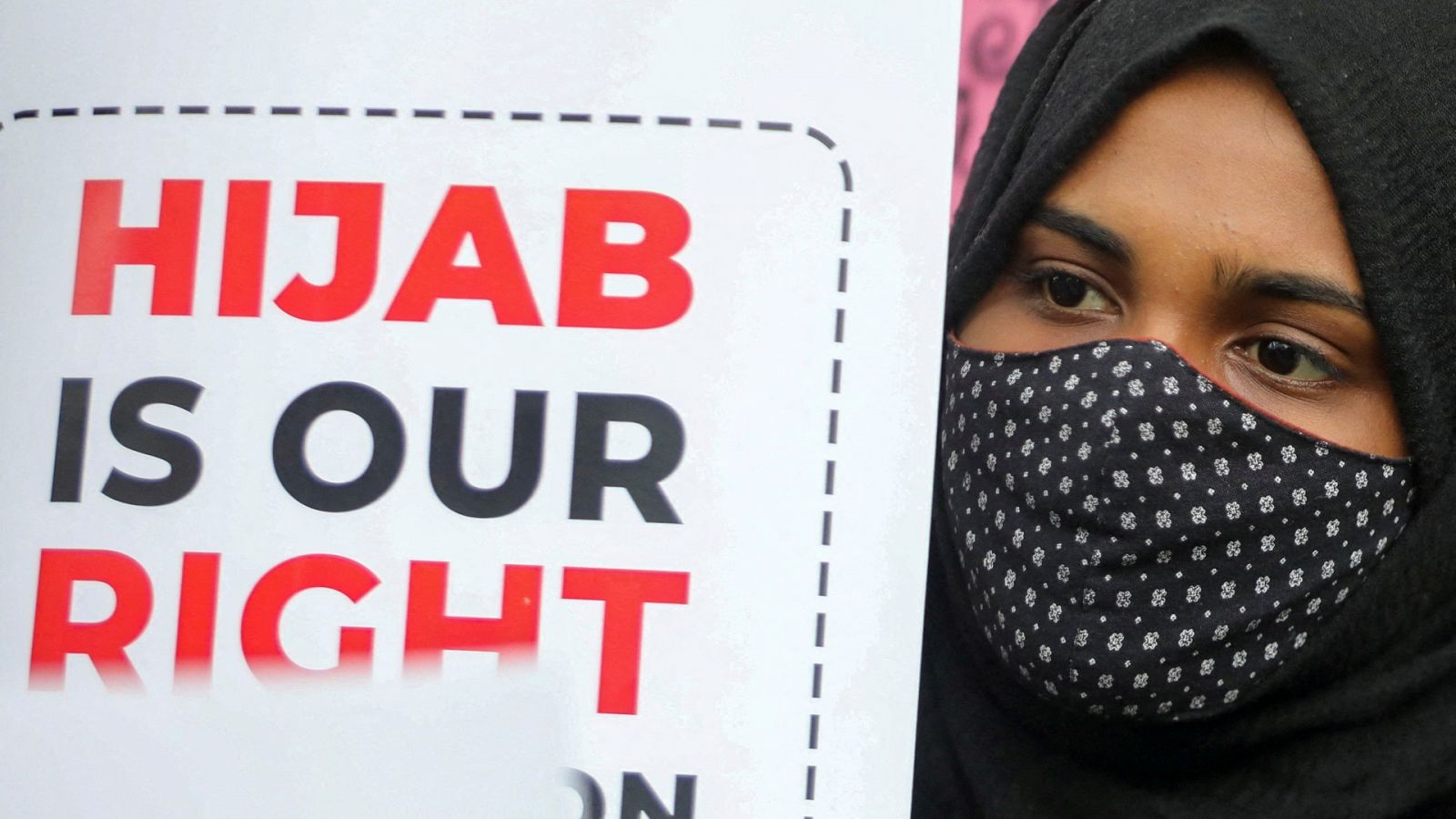 Una estudiante sostiene una pancarta durante una protesta contra la prohibición del hiyab