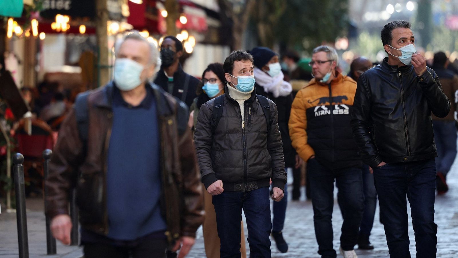Varias personas llevan mascarilla por la pandemia en una calle de París