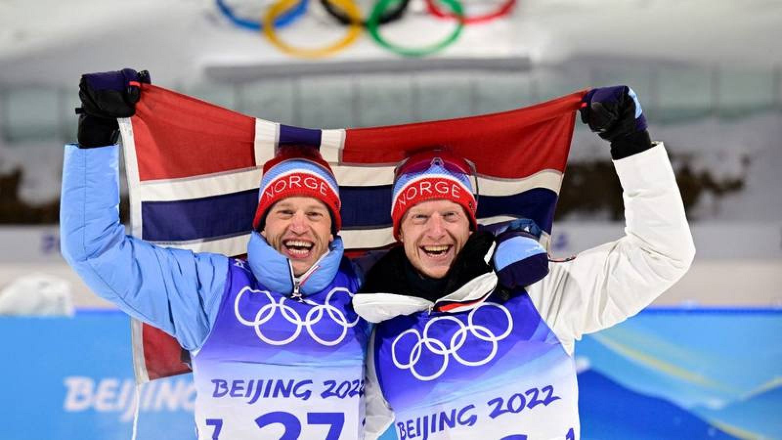 Imagen de Johannes Thingnes Boe y su hermano Tarjei en el podio del biatlón 10km de Pekín 2022.
