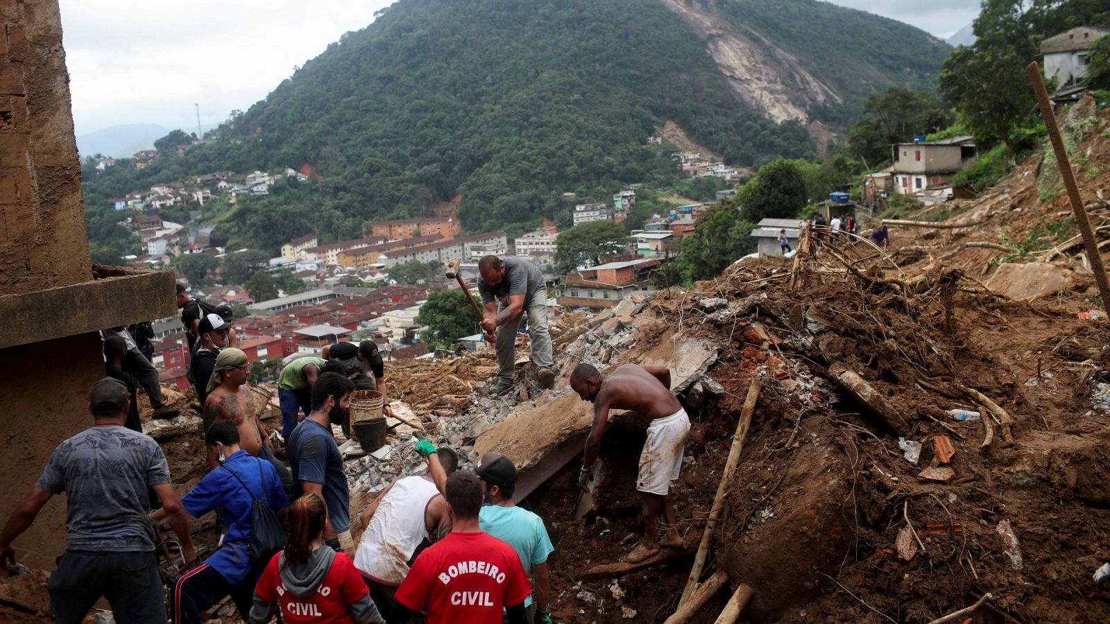 Personas trabajan en el lugar de un desprendimiento de tierra tras las lluvias torrenciales en Petrópolis