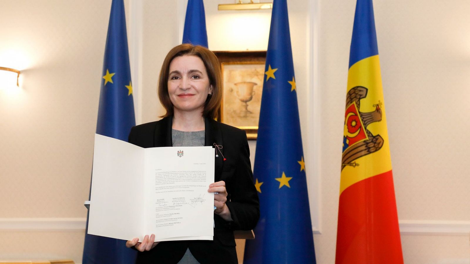 La presidenta de Moldavia, Maia Sandu, posa con la petición de ingreso oficial de su país a la Unión Europea
